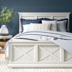 a bedroom with blue walls and white furniture