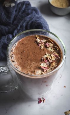 a glass mug filled with hot chocolate and granola florets on the side