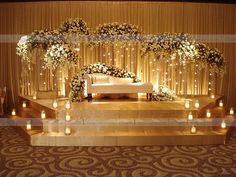 a stage set up with candles and flowers on the steps for a wedding ceremony or reception