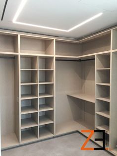 an empty walk in closet with white shelving