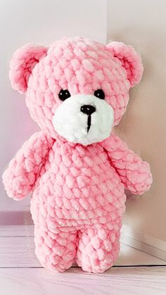 a pink teddy bear sitting on the floor