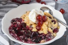 a close up of a bowl of food with ice cream and cherries on top