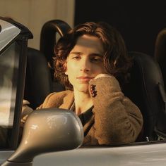 a woman sitting in the driver's seat of a car