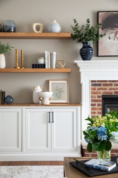 a living room filled with furniture and a fire place in front of a brick wall