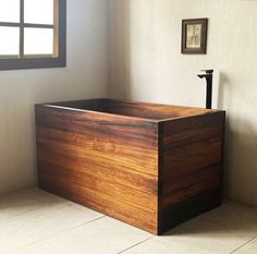 a wooden box sitting on top of a tiled floor next to a window in a room