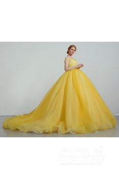 a woman in a yellow ball gown posing for the camera with her hands on her hips