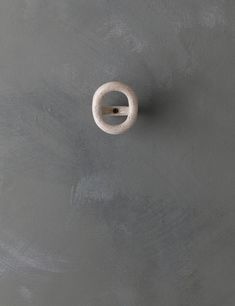 a white object is hanging on the wall in front of a gray background with black dots