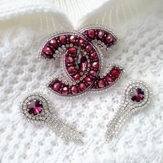 the brooch and ear clips are made out of red glass beads with crystal accents