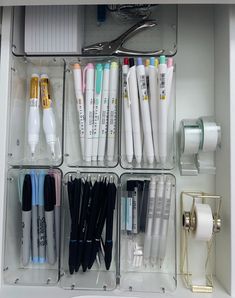 an organized drawer filled with pens, scissors and other office supplies