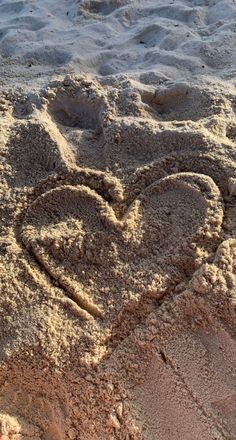 two hearts drawn in the sand on a beach