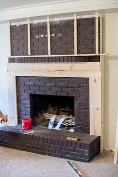 a man standing in front of a brick fireplace with some boxes on top of it