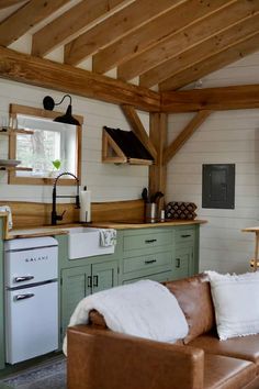 a living room filled with furniture next to a stove top oven and refrigerator freezer