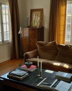 a living room with a couch, coffee table and books on top of each other