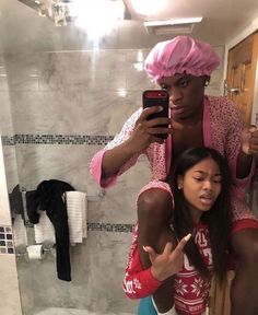 a woman taking a selfie with her friend in the bathroom