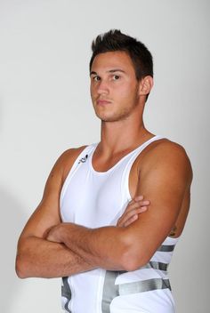 a man with his arms crossed wearing a tank top