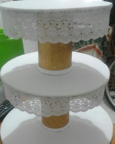 three tiered cake stand with white doily and gold glitter on the top layer