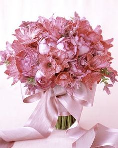 a bouquet of pink carnations wrapped in satin ribbon