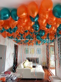 the room is decorated with balloons and streamers in shades of orange, teal, and turquoise