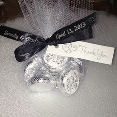 a silver car ornament with a black ribbon on it and a thank you tag