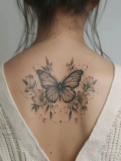 a woman with a butterfly tattoo on her back