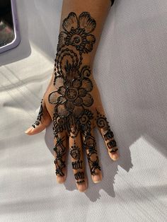 a woman's hand is decorated with hennap and flowers on the palm