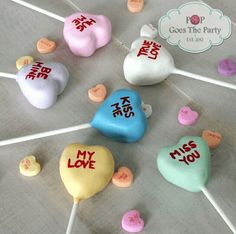 there are many heart shaped lollipops on the table with their name written on them