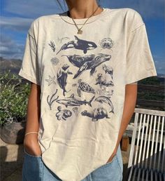 90s Tattoo Sea Animal Shirt, Vintage Dolphin Shirt, Retro Ocean Nature Shirt, Unisex Relaxed Adult Tee, Ocean Shirt, Whale Shirt, Sealife ⭐ INFORMATION: This unisex style t-shirt is suitable for both men and women. For care, wash the item inside out in cold water. Avoid bleach, dry cleaning, and direct ironing on the design. ⭐ MATERIAL DETAILS: Our heavyweight classic unisex tee is made from 5.3-ounce, 100% cotton, with variations of 99/1 cotton/poly (Ash) & 90/10 cotton/poly (Sport Grey). It fe Grunge Style Printed Short Sleeve Tops, Grunge Short Sleeve Printed Tops, Grunge Tops With Funny Print For Summer, Summer Grunge Tops With Funny Print, Grunge Shirt With Funny Print For Summer, Summer Grunge Shirt With Funny Print, 90s Style Summer Shirt With Funny Print, Womens Tshirt Designs, Ocean T Shirt