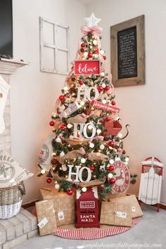 a christmas tree with presents under it and a chalkboard sign on the top that says hope