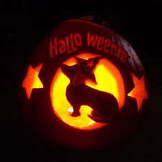 a pumpkin carved to look like a dog with the words halloween written in red on it