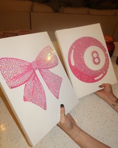 two handmade greeting cards with pink bow and number 8 on them, one being held up by a woman's hand