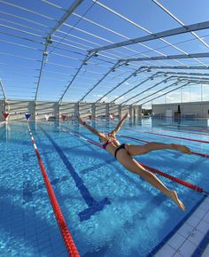 a woman is swimming in an indoor pool