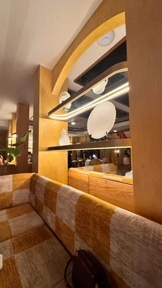 the interior of a restaurant with checkered couches and wooden tables in front of a mirror