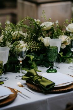 the table is set with white and green flowers