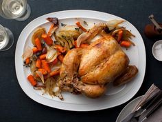 a white plate topped with a turkey and veggies on top of a table