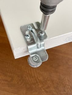 a close up view of a door hinge with a screwdriver on it