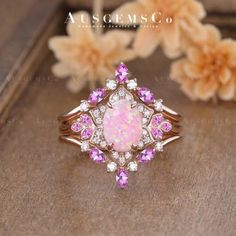 a pink opal and diamond ring sitting on top of a table