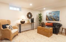 a living room filled with furniture and a painting on the wall