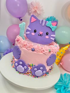 a birthday cake decorated to look like a cat with pink and purple frosting on it