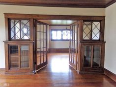 an empty room with wooden doors and windows