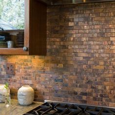 a stove top oven sitting inside of a kitchen next to a wooden cabinet and window