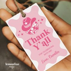 a hand holding a pink thank you card with a hat on it's tag