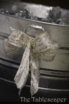 a bow is tied on the top of a metal bucket filled with ice cubes