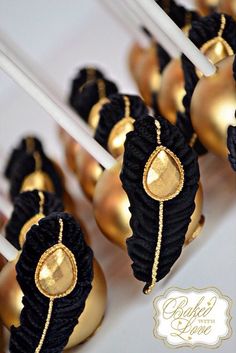 some gold and black desserts are sitting on a table