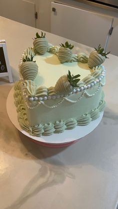 a heart shaped cake sitting on top of a white table next to a photo frame