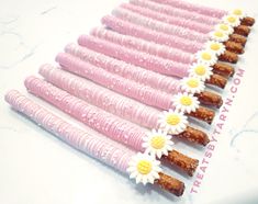 there are many pink and white flowers on the sticks that have been made to look like daisies