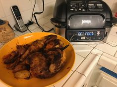 a yellow plate topped with meat next to an air fryer