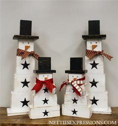 two snowmen made out of wooden blocks with black and red bows