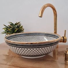 a bowl sink sitting on top of a wooden counter next to a faucet