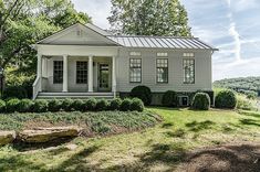 a white house sitting on top of a lush green field