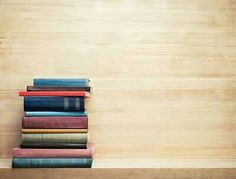 a stack of books sitting on top of a wooden shelf